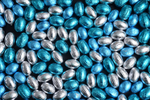 istock Blue,  silver and turquoise foil wrapped chocolate easter eggs, against a black background. 1465357793