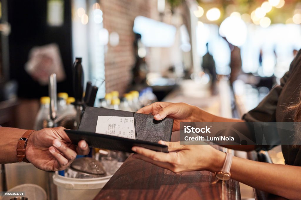 Hands with bill, food service and people in restaurant, customer with receipt and payment with cashier or waiter. Fine dining, dinner and check at cafe, catering and hospitality with finance Restaurant Stock Photo