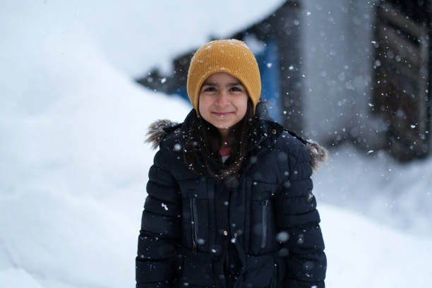 istock Little girl having fun outside while it's snowing 1465364441