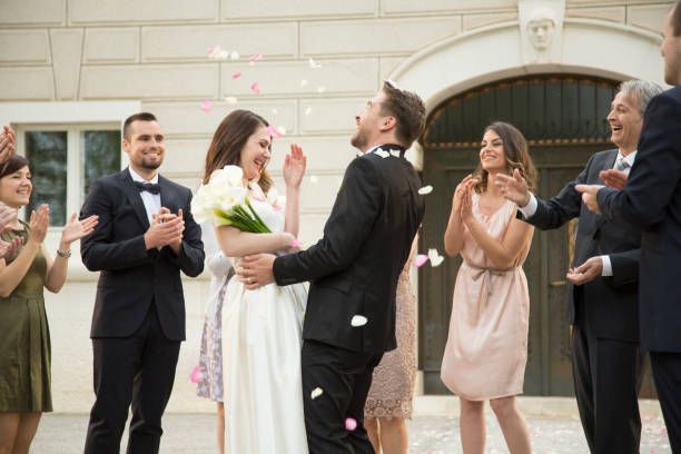 istock Guests throwing rose petals on bride and groom 1465364519