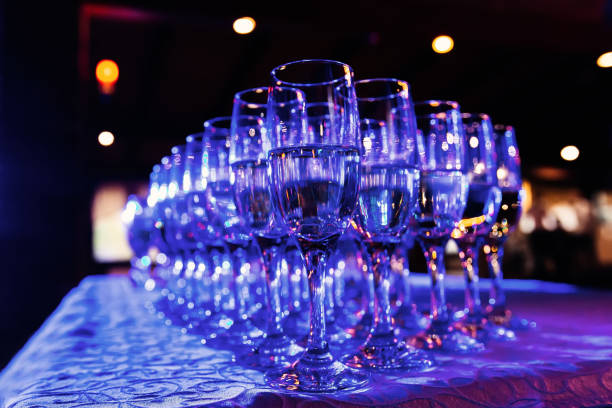 istock a close-up of champagne glasses standing in several rows on a table with a tablecloth and blue light shines on them 1465365985