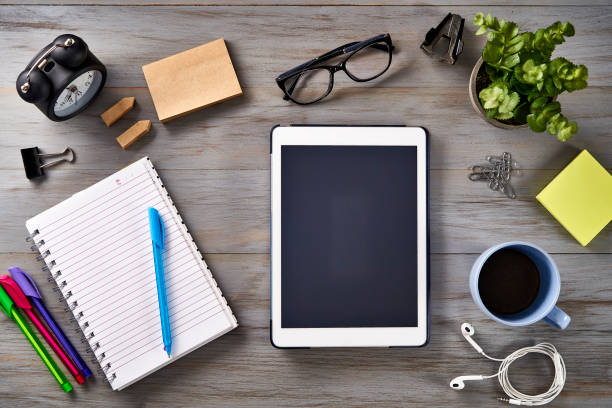 New year resolutions theme: Top view of Notepad, smartphone, digital tablet, clock and sticky notes on a table at home office