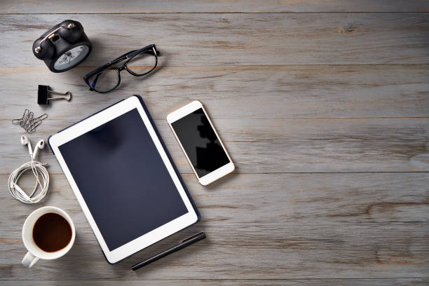 istock Top view of Notepad, smartphone, digital tablet, clock and sticky notes on a table with copy space 1465369722