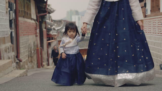 A cute female tourist and her daughter wearing Hanbok while traveling in South Korea.