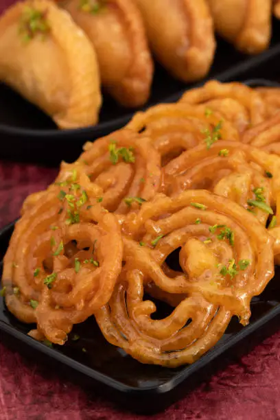 Jalebi Also Called Jilapi, Jilebi, Jilipi, Zulbia, Jerry, Zalebi, Mushabak Is Indian Mithai Made Of Fermented All Purpose Flour Maida, Besan Fried In Desi Ghee Dunked In Sugar Syrup Cheeni Ki Chasni