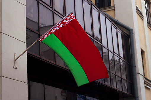 red and green belarussian flag on the wall of Administration Building - cityscape with big windows, Republic of Belarus, Belorussian Government