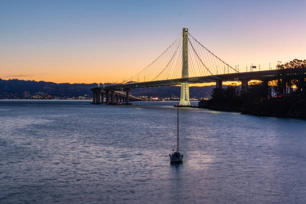 Early morning view of the Bay Bridge with a sailboat in the foreground Early morning view of the Bay Bridge with a sailboat in the foreground san francisco bay stock pictures, royalty-free photos & images