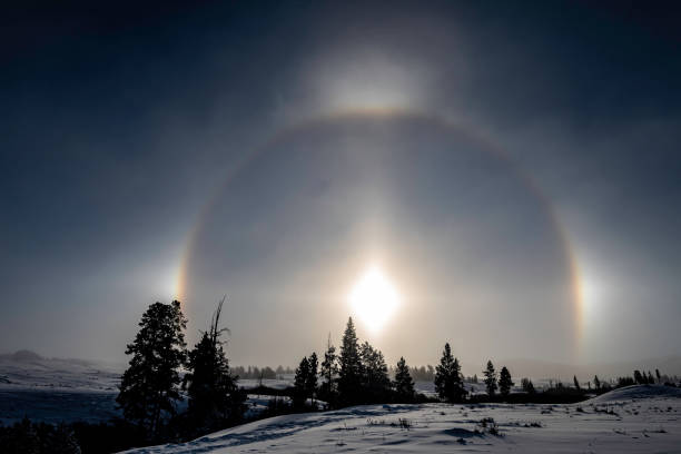 A sun dog (or sundog) or mock sun, also called a parhelion in meteorology, is an atmospheric optical phenomenon that consists of a bright spot to one or both sides of the Sun. Two sun dogs often flank the Sun within a 22° halo. Yellowstone National Park, Wyoming.