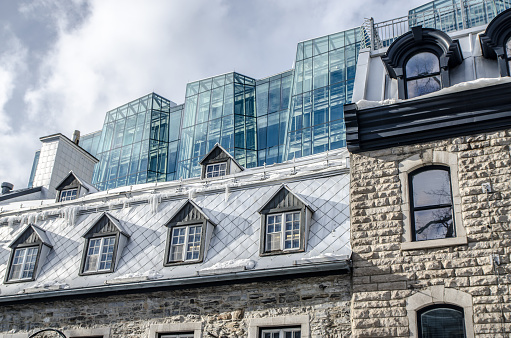 Modern glass building behind old stone building during day in Quebec city