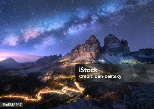 istock Milky Way, car light trails on mountain road, high rocks at starry night in summer. Tre cime, Dolomites, Italy. Colorful landscape with blurred light trails, hills, mountain peaks, sky with stars 1465384947