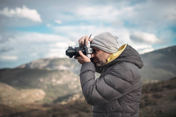 istock Photographer taking picture in mountains 1465388384