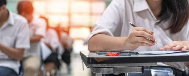 istock Exam at school with student's taking educational admission test in class, thinking hard, writing answer in university classroom, education and world literacy day concept 1465411204