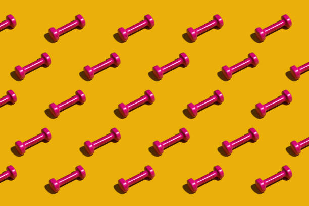istock Bright pink dumbbells on a yellow background 1465412788