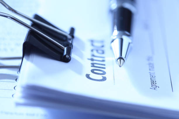 A close up of a  ballpoint pen resting on top of a contract that is ready for signing.