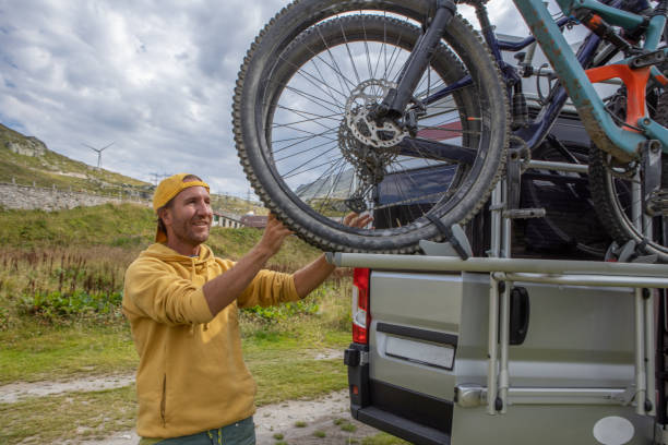 istock Man loading mountain bikes on the back of a van on a bike rack 1465414182