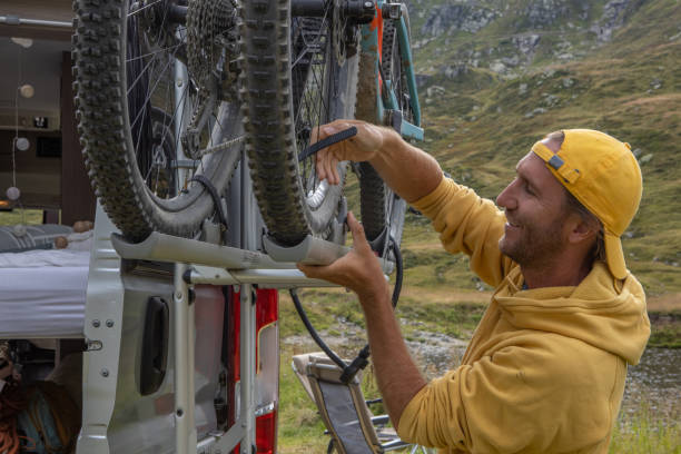 istock Man loading mountain bikes on the back of a van on a bike rack 1465414221