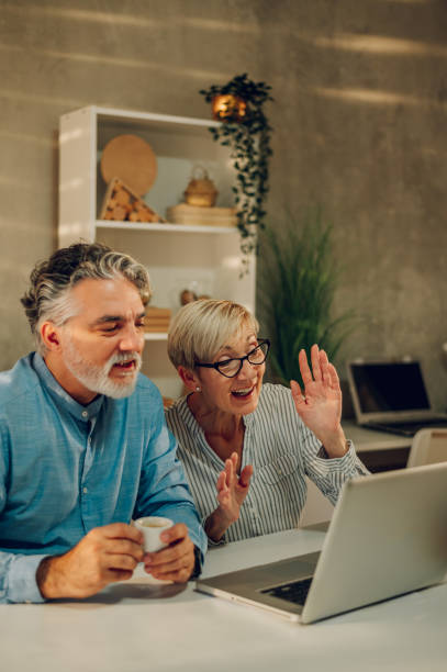 istock Senior couple using a laptop at home 1465415644