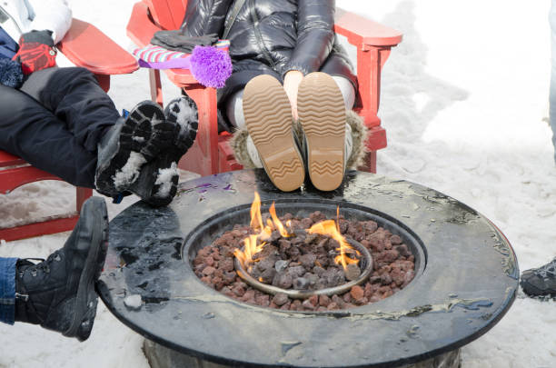 People warming their feet over fire camp stock photo