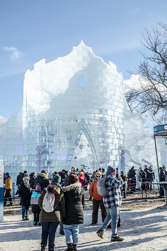 Facade of the Bonhomme Carnaval Ice Castle with people in line to visit it during winter day in Quebec city