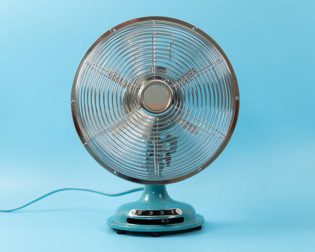Vintage tabletop fan isolated on a blue background stock photo