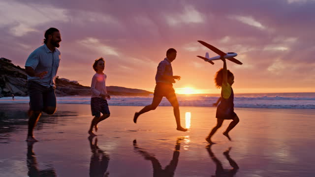Happy family, sunset and children on beach toy airplane, running and playing on sand in silhouette in Hawaii. Travel, summer evening ocean and kids with mom and dad, fun tropical island holiday.