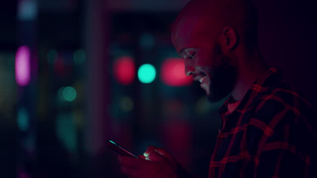 Black man, night and street for texting with phone, social network or book taxi for transport in metro. Happy young guy, smartphone and chat app for networking, dating and mock up space in dark city
