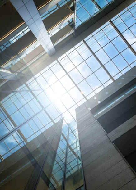 Modern office building, low angle shot with sky view and sun flares.
