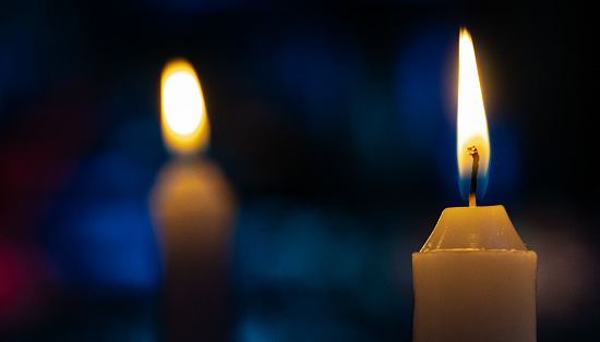 Burning candle with dark blue background