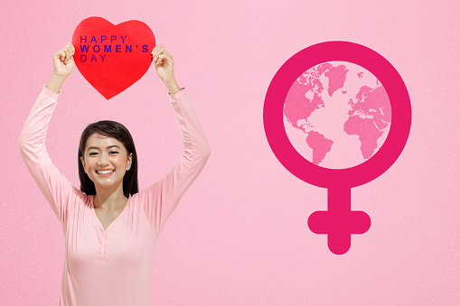 Asian woman showing heart with Happy Women's Day text. International Women Day
