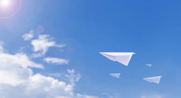 istock A paper airplane is flying in the beautiful clear sky. 1465443552