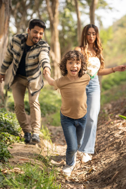 istock Excited boy dragging his parents for a walk in the park 1465443880