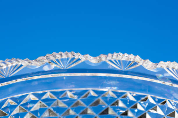 Crystal glass bowl surface with diamond facets This abstract macro image shows a lead crystal glass bowl surface with diamond facet cuts, with blue sky background. lead cut glass crystal stemware stock pictures, royalty-free photos & images