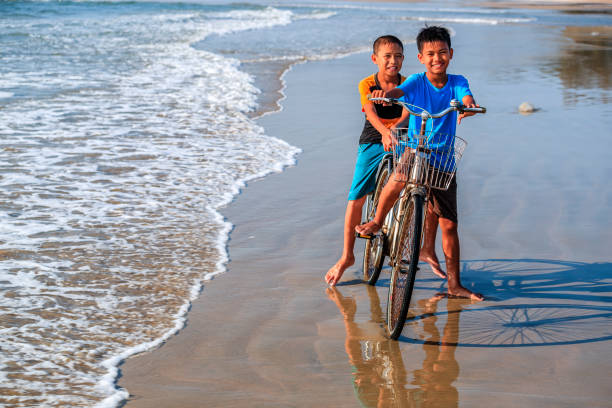 istock Vietnamese young boys riding a bicycle on the beach, Vietnam 1465444810