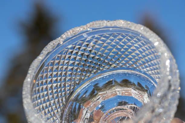 Crystal glass bowl surface with diamond facets This abstract macro image shows a lead crystal glass bowl surface with diamond facet cuts, with blue sky background. lead cut glass crystal stemware stock pictures, royalty-free photos & images