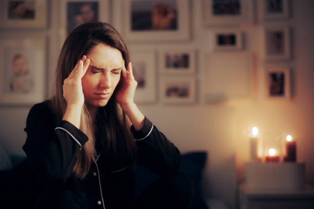 Femme stressée souffrant d’une migraine la nuit avant d’aller dormir - Photo