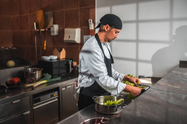 istock Mature Asian Chef, in a White Uniform, Washes Vegetables 1465447065