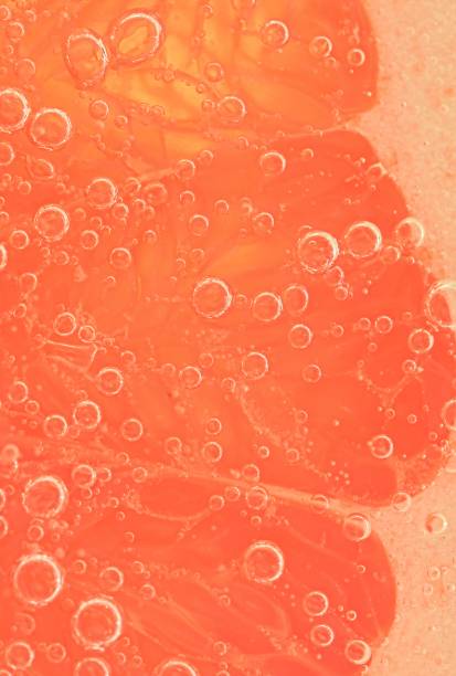 istock Red grapefruit slice floating in club soda. Fresh grapefruit slice with bubbles in carbonated drink. Fresh natural red grapefruit slice covered by bubbles 1465448126