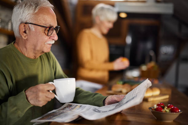 istock Senior man drinking coffee and reading newspapers at home. 1465453712