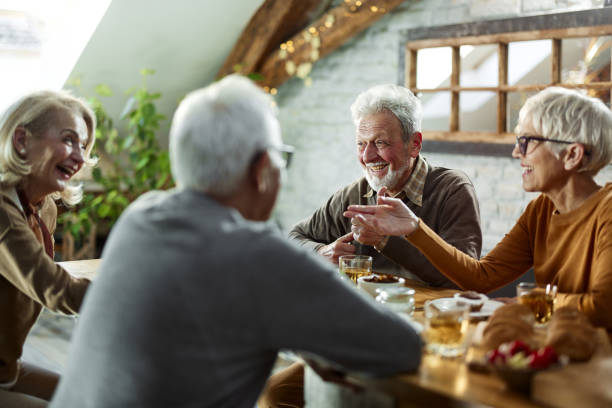 istock Happy mature couples enjoying in conversation during a meal at dining table. 1465454521