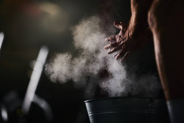 Close up of unrecognizable athlete preparing his hands with powder.