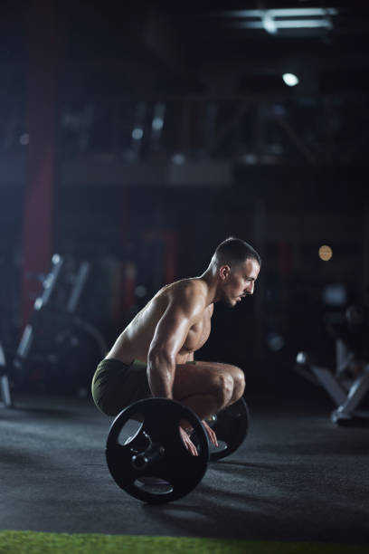 istock Determined sportsman exercising with barbell in a gym. 1465454902