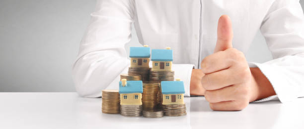 istock House Residential Structure in hand ,model house and coin 1465458163