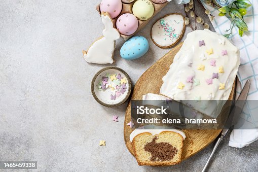 istock Happy Easter holiday food baking, cupcake with Easter Bunny and colorful eggs on stone background. View from above. Copy space. 1465459338