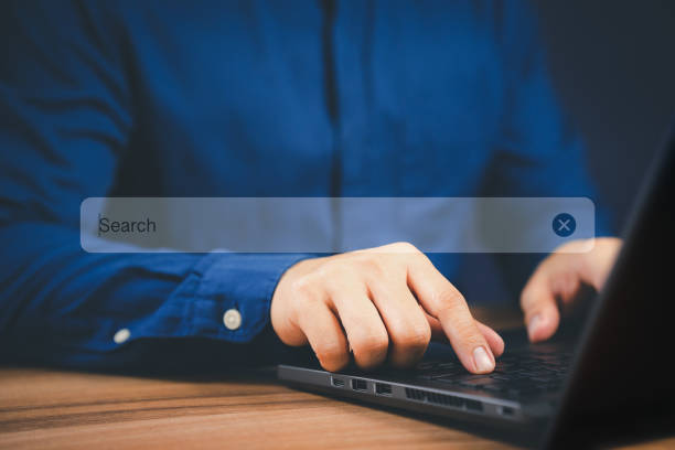 istock Businessman's hand working with computer laptop on desk in home. Searching Browsing Internet Data Information with blank search bar. Search Engine Optimization SEO Networking Concept. 1465460171