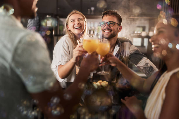 parejas jóvenes felices brindando en una fiesta en casa. - home interior cocktail bar women fotografías e imágenes de stock