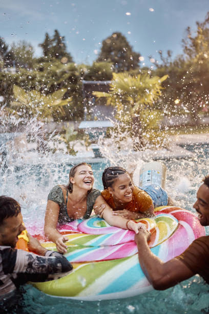 istock Cheerful couples having fun on a pool raft at the swimming pool. 1465463068