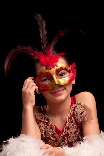 Young girl wearing masquerade mask.