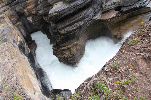 Elevated view of rocky ravine with ice water stream, Jasper National Park, Alberta, Canada.