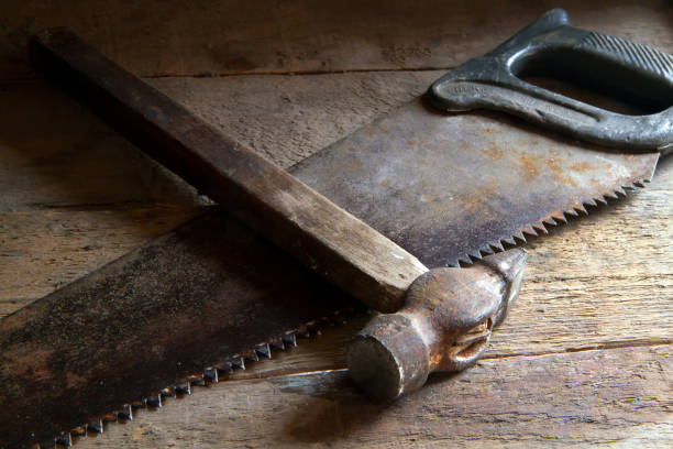 Old hacksaw and hammer on the boards.