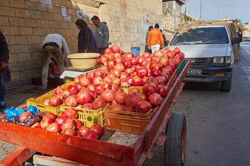 Sousse, Tunisia, January 15, 2023: Carts with a mountain of pomegranates next to the wall of the medina in Sousse